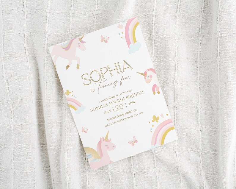 May include: A white invitation card with a unicorn theme. The card features a pink unicorn, rainbows, and butterflies. The text reads "SOPHIA is turning four" with the date July 20 and the time 2 PM.