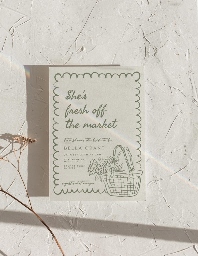 May include: A light-colored invitation with a scalloped border and the text "She's fresh off the market." Below, it reads "let's shower the bride-to-be BELLA GRANT." A drawing of a basket with flowers is included.
