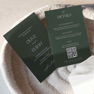 May include: A green wedding invitation with white text. The invitation is for Olive and Elijah's wedding on Saturday, July 16th, 2022 at 4:00 pm at Kingsbrae Garden, 220 King Street St. Andrews. The back of the invitation has details about the wedding, including accommodations, reception, and RSVP information. There is a QR code for the RSVP website.