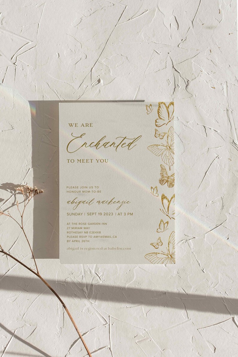 Pu&ograve; includere: Un invito color crema con scritte dorate e decorazioni a farfalla. Il testo recita "Siamo incantati di incontrarvi" e include i dettagli dell'evento per la celebrazione di Abigail Mackenzie. Su sfondo bianco strutturato.