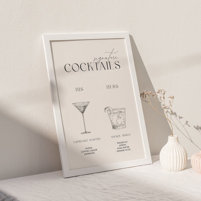 Peut inclure: Une affiche encadr&eacute;e blanche avec le texte "Signature Cocktails" en haut. L'affiche est divis&eacute;e en deux sections, "His" et "Hers", avec une recette de cocktail list&eacute;e sous chaque section. Le cocktail "His" est un Espresso Martini, et le cocktail "Hers" est un Aperol Spritz.
