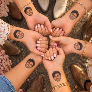 Puede incluir: Seis mu&ntilde;ecas dispuestas en c&iacute;rculo, cada una con un peque&ntilde;o tatuaje temporal del rostro del mismo hombre sonriente. Las mu&ntilde;ecas est&aacute;n adornadas con varios brazaletes de cadena dorados y u&ntilde;as manicuradas en tonos blanco y rosa.