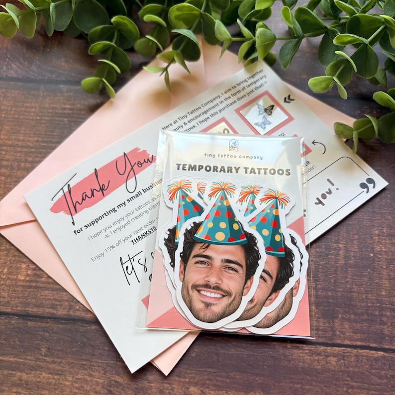 Puede incluir: Una funda de pl&aacute;stico transparente con varios tatuajes temporales que muestran a una persona sonriente con un gorro de fiesta azul verdoso con lunares naranjas y borla roja sobre una tarjeta blanca con el texto TEMPORARY TATTOOS.