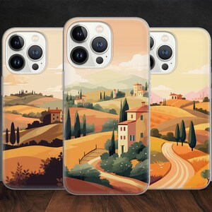 May include: Three phone cases with a colorful illustration of a countryside landscape with houses, trees, and a winding road. The cases are clear and show the phone's camera lens.