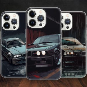 Könnte beinhalten: Drei Handyhüllen mit Autoillustrationen. Die Hüllen zeigen verschiedene klassische Autodesigns in Grau-, Schwarz- und Brauntönen. Die Autos sind in einer stilisierten, künstlerischen Weise dargestellt, wobei Details wie Scheinwerfer und Karosserielinien sichtbar sind.