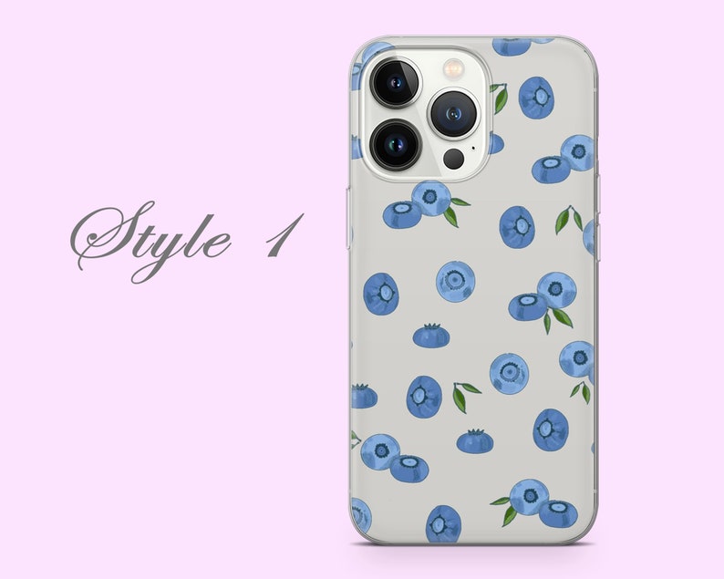Puede incluir: Una funda transparente para tel&eacute;fono con un patr&oacute;n de ar&aacute;ndanos azules sobre un fondo blanco. La funda est&aacute; dise&ntilde;ada para un iPhone con una lente de c&aacute;mara triple.