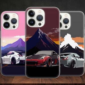 May include: Three phone cases with different colored backgrounds and mountain scenes. Each case features a white, gray, or black sports car with a red accent.