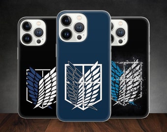 Może przedstawiać: Trzy etui na telefon w kolorze niebieskim, czarnym i białym. Każde etui przedstawia stylizowane zdjęcie pary skrzydeł z geometrycznym wzorem. Skrzydła są symbolem popularnego anime Attack on Titan.