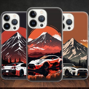 Op de afbeelding: Drie telefoonhoesjes met een berg- en sportwagenontwerp. De hoesjes zijn transparant en tonen de cameralenzen van de telefoon. De berg is wit met een rode zonsondergang erachter. De sportwagen is rood en zwart.