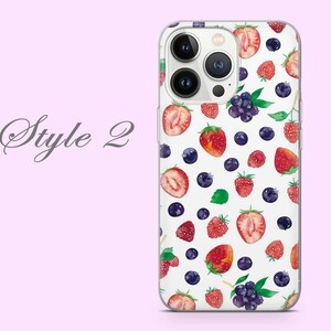 Puede incluir: Una funda transparente para tel&eacute;fono con fondo blanco y un patr&oacute;n de fresas rojas, ar&aacute;ndanos y frambuesas. La funda tiene un recorte para el objetivo de la c&aacute;mara.