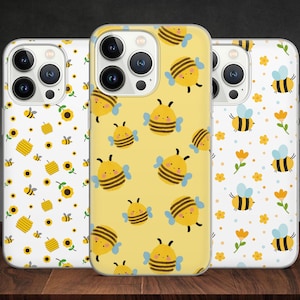 Puede incluir: Tres fundas para iPhone con diferentes diseños de abejas. La primera funda tiene un fondo blanco con panal de abejas amarillo, abejas y girasoles. La segunda funda tiene un fondo amarillo con abejas y flores. La tercera funda tiene un fondo blanco con abejas y flores.