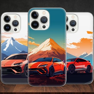 Könnte beinhalten: Drei transparente Handyhüllen mit einem Berg- und Sportwagen-Design. Die Hüllen sind für ein iPhone mit einer Kamerabuckel. Die Hüllen liegen auf einer Holzoberfläche.