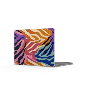 Può includere: Un laptop con un design astratto e colorato. La custodia presenta un motivo di forme sovrapposte nelle tonalità di arancione, viola, rosa, blu e nero. La parola "VAULT" è stampata sulla custodia.