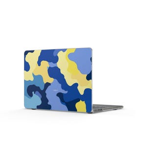 Può includere: Un laptop con un design mimetico nei toni del blu e del giallo. La custodia del laptop presenta un motivo di forme irregolari e la parola "VAULT" è stampata.