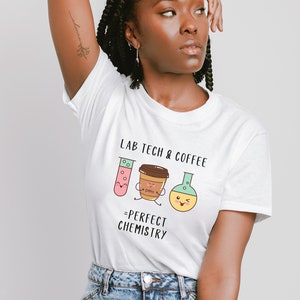 May include: White t-shirt with a graphic of a test tube, coffee cup, and beaker with the text "Lab Tech & Coffee = Perfect Chemistry".