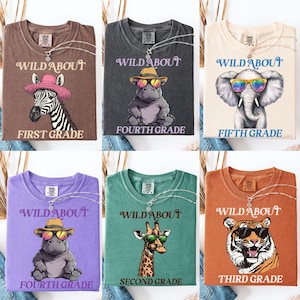 May include: A collection of six t-shirts in various colors, each featuring a different animal wearing sunglasses and a hat. The shirts have the text "WILD ABOUT" above the animal and a grade level below.