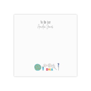 May include: To Do List notepad with a white background and a handwritten name "Amelia Jones" at the top. The bottom of the notepad features a colorful illustration of a petri dish, a test tube, a DNA strand, a magnifying glass, and a pipette. The text "DNA" is written in colorful letters below the illustration.
