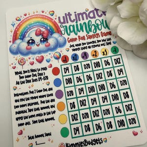 May include: A colorful savings game card with a rainbow, cloud, and hearts design. The card features the text "ultimate rainbow Color Roll Savings Game" and instructions for playing. The card includes a grid for tracking savings.