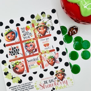 May include: A white and black polka dot background with a tic-tac-toe game board featuring cute strawberry illustrations. The game board has the text "So Berry Cute", "You Are Berry Special", "Sweetest Berry In The Patch", "I Love You Berry Much!" and "Kimmilspudglis Tic-Tac Strawberry Patch".