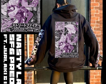 May include: A black hooded sweatshirt featuring a large rectangular graphic on the back with purple and white anime-style illustrations of characters, Japanese text, and the words Street Fighter. The sleeves also feature printed graphic designs.