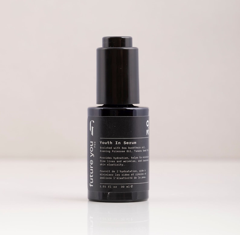 May include: A black glass bottle with a dropper top containing a serum called "Youth In Serum" by the brand "future you PSS". The bottle is labeled with the text "Enriched with Sea buckthorn oil, Evening Primrose Oil, Tamanu Seed Oil" and "Provides hydration, helps to smooth fine lines and wrinkles, and support skin elasticity."
