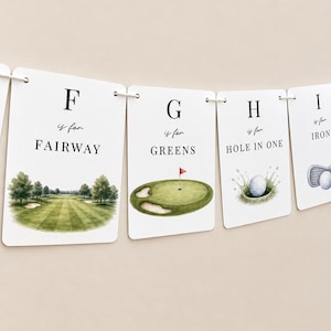May include: A decorative banner featuring white rectangular cards strung together. Each card displays a letter of the alphabet, the phrase 'is for', and a golf-themed word with a corresponding watercolour illustration, including F for FAIRWAY, G for GREENS, H for HOLE IN ONE, and I for IRON.