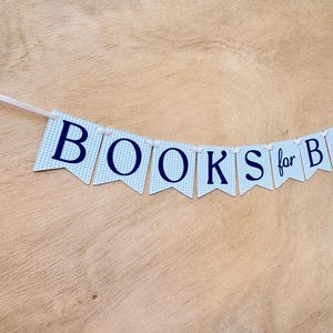 K&ouml;nnte beinhalten: Ein Banner mit blau-wei&szlig; karierten Wimpeln schreibt "BOOKS for B". Die Buchstaben sind marineblau. Das Banner ist auf einem wei&szlig;en Band aufgereiht, und der Hintergrund ist eine hellbraune Holzoberfl&auml;che.