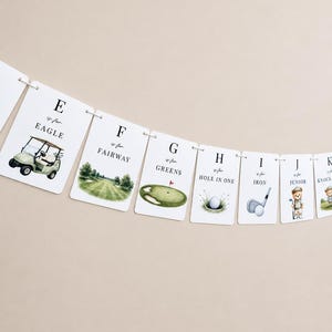 May include: A decorative banner featuring a series of white rectangular cards strung together. Each card displays a letter of the alphabet, the phrase 'is for', and a golf-themed illustration including an eagle, fairway, greens, and a junior golfer.