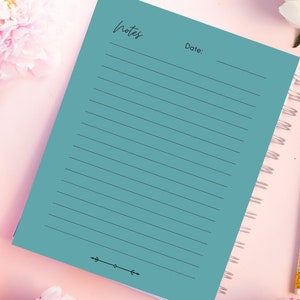 May include: A teal blue notebook with a spiral binding and the word "Notes" written at the top. The notebook has lined pages and a decorative design at the bottom.