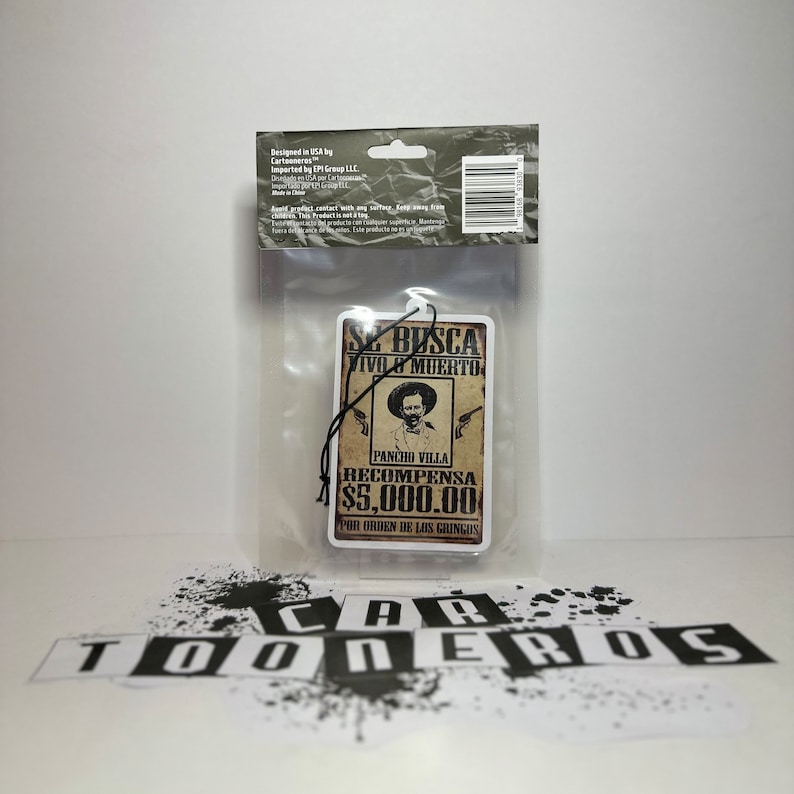 May include: A brown and white car air freshener with a vintage wanted poster design. The poster features a drawing of a man with a mustache and a hat, and the text "Se Busca Vivo o Muerto Pancho Villa Recompensa $5,000.00 Por Orden de los Gringos".