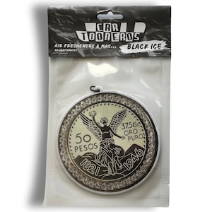 Pu&ograve; includere: Un profumatore per auto rotondo e bianco con un design argento e oro. Il design presenta una figura alata che tiene una ghirlanda, con il testo "50 PESOS 1821 1946 37.5G ORO PURO" attorno al bordo.