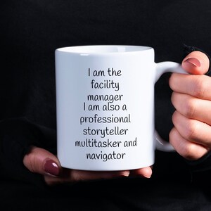 May include: White ceramic mug with black text that reads "I am the facility manager I am also a professional storyteller multitasker and navigator".