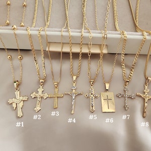May include: Eight gold necklaces with different styles of cross pendants. The crosses are all gold and have different designs, including a dove, a simple cross, and a cross with rhinestones. The necklaces are numbered 1 through 8.
