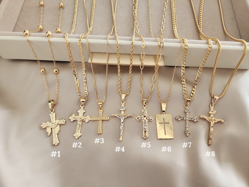 May include: Eight gold necklaces with different styles of cross pendants. The crosses are all gold and have different designs, including a dove, a simple cross, and a cross with rhinestones. The necklaces are numbered 1 through 8.
