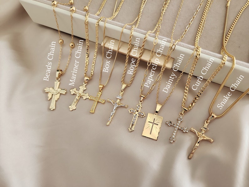 May include: Nine gold chains in different styles, each with a gold cross pendant. The chains are labelled with their names: Beads Chain, Mariner Chain, Box Chain, Rope Chain, Paperclip Chain, Dainty Chain, Curb Chain, and Snake Chain.