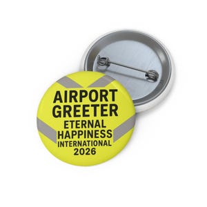 Może przedstawiać: Żółta przypinka z czarnym napisem "AIRPORT GREETERS ETERNAL HAPPINESS INTERNATIONAL 2026". Przypinka ma szare odblaskowe paski i srebrny tył z agrafką.