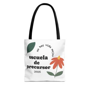 May include: White tote bag with black handles featuring the text "escuela de precursor 2026" and a flower graphic. The bag also has the phrase "no hay vida mejor" in a circular design.