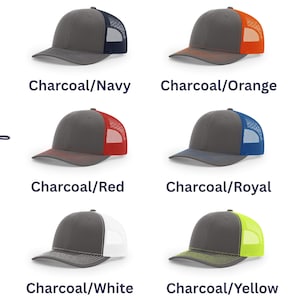 May include: Six trucker hats with charcoal front panels and brims, featuring mesh back panels in navy, orange, red, royal blue, white, and neon yellow. The text "Choice of color" is written vertically on the left side of the image.