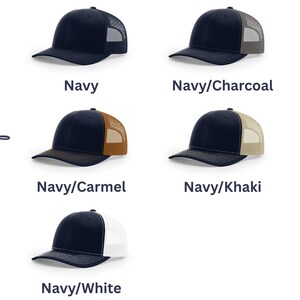 May include: Five trucker hats with navy blue front panels and brims, featuring mesh back panels in navy, charcoal, carmel, khaki, and white. The text Choice of color is displayed vertically on the left side of the image next to the hats.