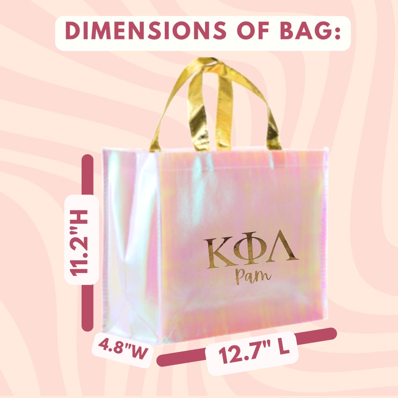 K&ouml;nnte beinhalten: Eine rosa irisierende Tragetasche mit goldenen Henkeln und den griechischen Buchstaben "&Kappa;&Phi;&Lambda;" sowie dem Namen "Pam" in Gold gedruckt. Die Tasche misst 11,2 Zoll in der H&ouml;he, 12,7 Zoll in der Breite und 4,8 Zoll in der Tiefe.