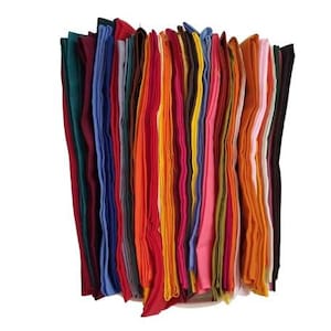 May include: A collection of folded fabric in various colors, including red, orange, pink, blue, and green. The fabrics are stacked together, creating a vibrant display of textiles. The image is set against a plain white background.
