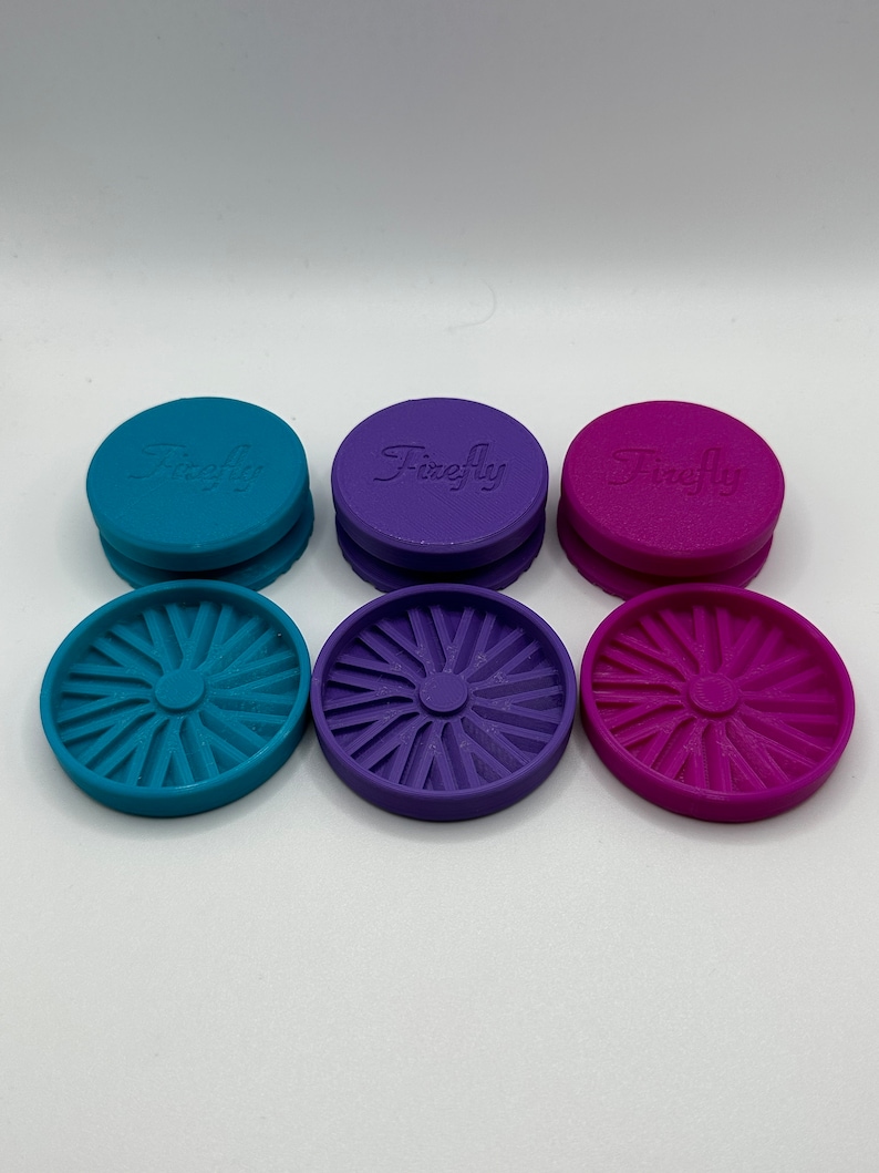 Puede incluir: Tres juegos de tapas redondas de pl&aacute;stico de colores con la palabra "Firefly" en relieve en la parte superior. Las tapas son de color turquesa, morado y rosa. Cada tapa tiene un dise&ntilde;o circular decorativo en la parte inferior.