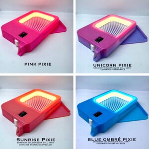 K&ouml;nnte beinhalten: Vier farbenfrohe, rechteckige Leuchten mit leuchtendem Innenraum und einem kleinen Schalter. Die Leuchten sind in Pink, Lila, Rot und Blau gehalten. Jede hat einen anderen Namen: Pink Pixie, Unicorn Pixie, Sunrise Pixie und Blue Ombre Pixie. Der Text "Gradient color/color will vary" ist ebenfalls vorhanden.