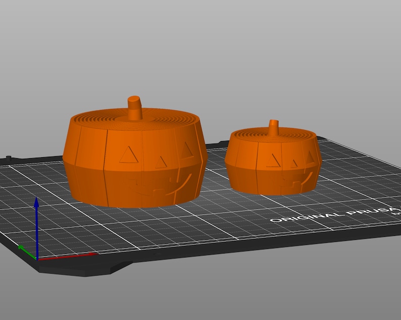 Pu&ograve; includere: Due portacandele a forma di zucca stampati in 3D di colore arancione. Il pi&ugrave; grande &egrave; in primo piano e il pi&ugrave; piccolo &egrave; sullo sfondo.