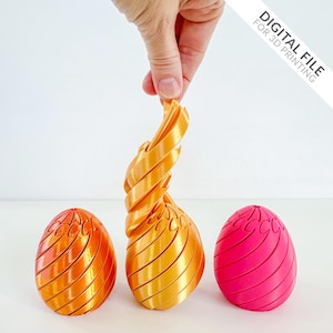 Peut inclure: Ensemble d'objets décoratifs en forme d'œuf imprimés en 3D. L'un est tenu par une main. Les objets sont dans des tons orange et rose. Le texte "DIGITAL FILE FOR 3D PRINTING" est dans le coin supérieur droit.