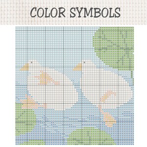K&ouml;nnte beinhalten: Ein Kreuzstichmuster mit der &Uuml;berschrift COLOR SYMBOLS zeigt zwei wei&szlig;e V&ouml;gel vor einem hellblauen Hintergrund mit gr&uuml;nen, kreisf&ouml;rmigen Blattelementen. Das Rasterdesign verwendet verschiedene Symbole zur Angabe der Garnfarben.