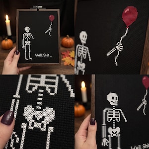K&ouml;nnte beinhalten: Eine Kreuzstichstickerei in einem dunklen Holzrahmen mit einem wei&szlig;en Skelett auf schwarzem Grund. Dem Skelett fehlt ein Arm, w&auml;hrend eine abgetrennte Skeletthand einen roten Luftballon h&auml;lt. Der Text "Well, Shit..." ist in Wei&szlig; gestickt.