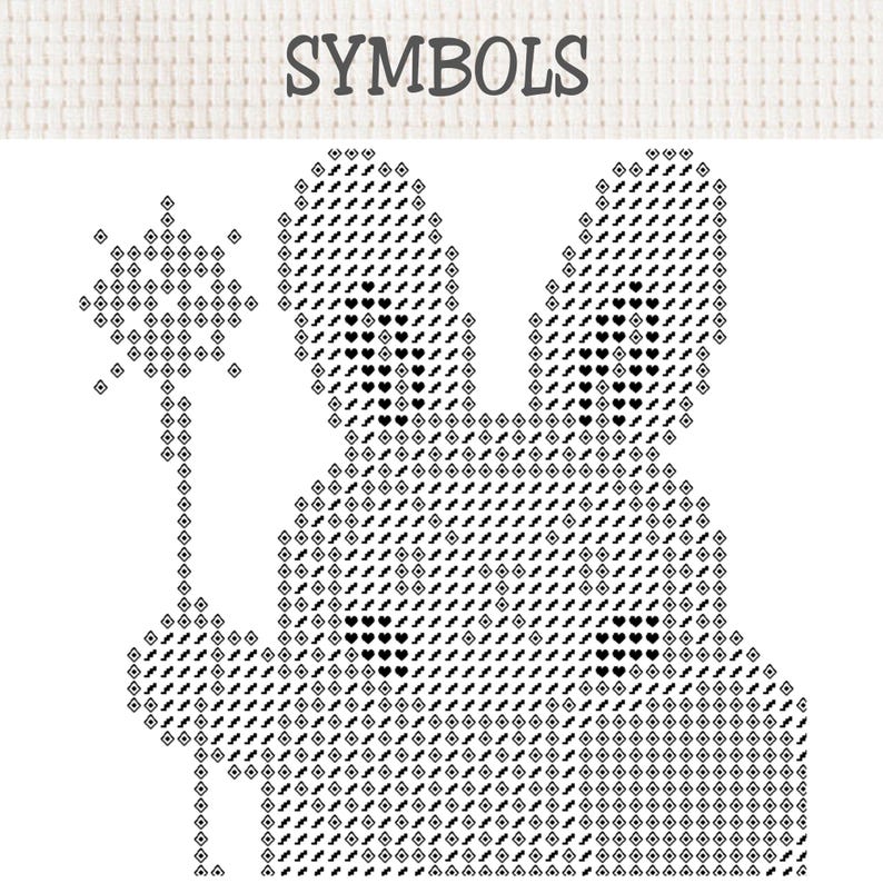 以下が含まれることがあります： 上部に「SYMBOLS」とラベル付けされたクロスステッチのパターンチャート。星型の杖を持ったウサギの白黒グラフィックが描かれています。デザインは、ひし形、ハート、ジグザグ線など、さまざまな幾何学模様の記号で構成されています。