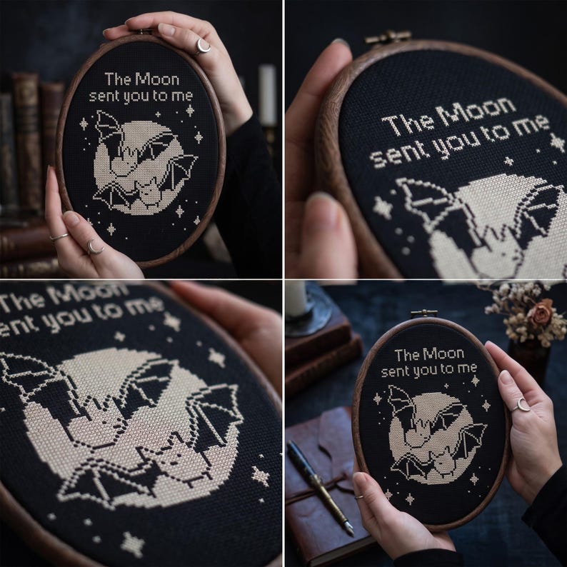 Puede incluir: Un bastidor de bordado ovalado con tela negra y un dise&ntilde;o de punto de cruz de dos murci&eacute;lagos frente a una luna grande. El texto "The Moon sent you to me" est&aacute; bordado en blanco sobre la luna, rodeado de peque&ntilde;as estrellas blancas.