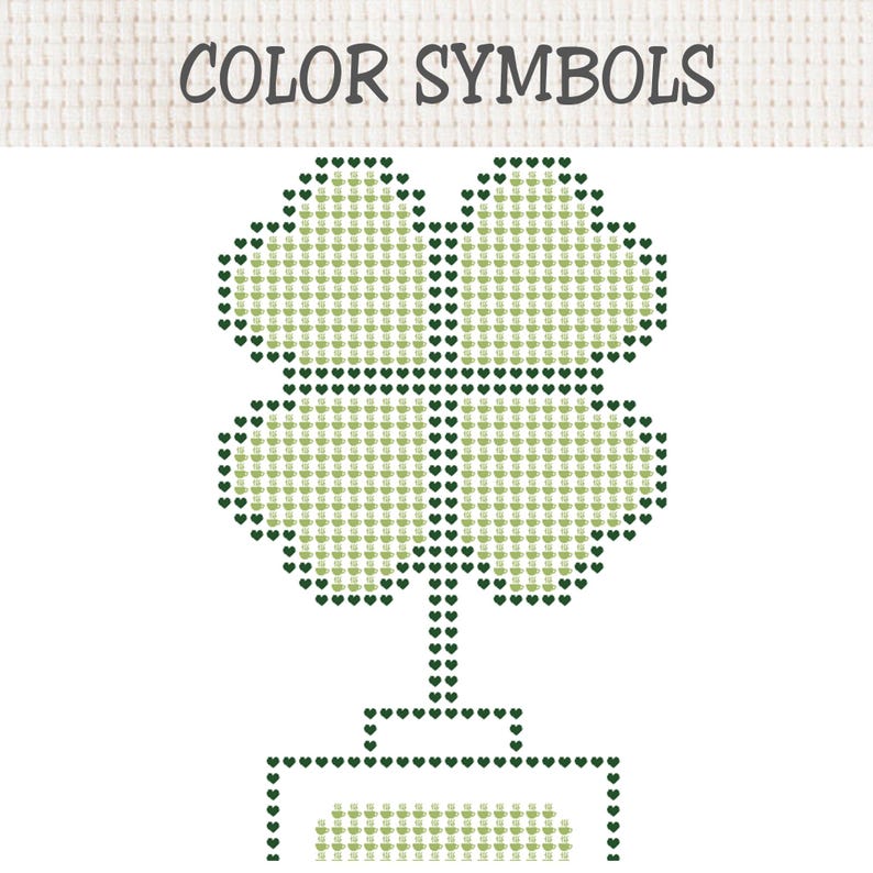 May include: A cross-stitch pattern chart titled COLOR SYMBOLS featuring a four-leaf clover design. The clover is outlined in dark green heart icons and filled with light green coffee cup symbols. A rectangular base is also outlined in dark green hearts.